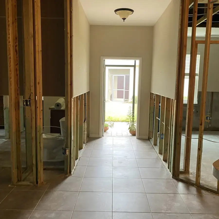 Hallway with the lower drywall removed and framing exposed for drying